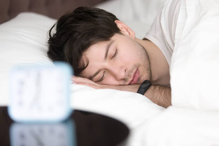 בדיקת שינה – מה זה ולמה עושים את זה? 7 young man sleeping alarm clock wearing smart wristband